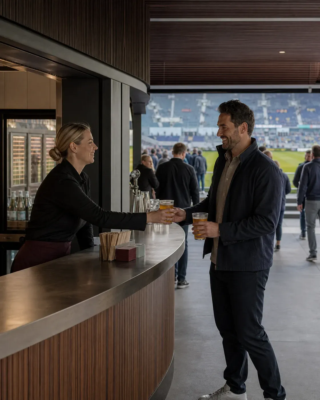 Illustrative scene of a team member handing drinks to supporters at a stadium concourse collection counter, with the stands behind them.