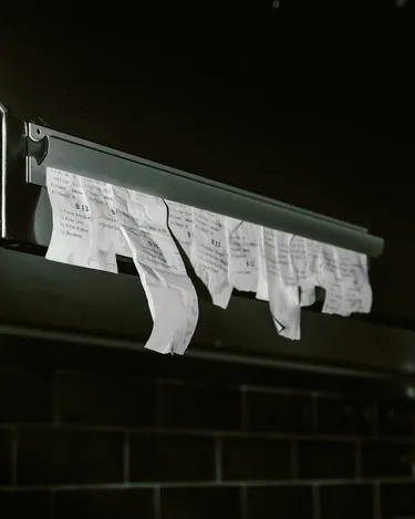 Order receipts hanging at a kitchen stall